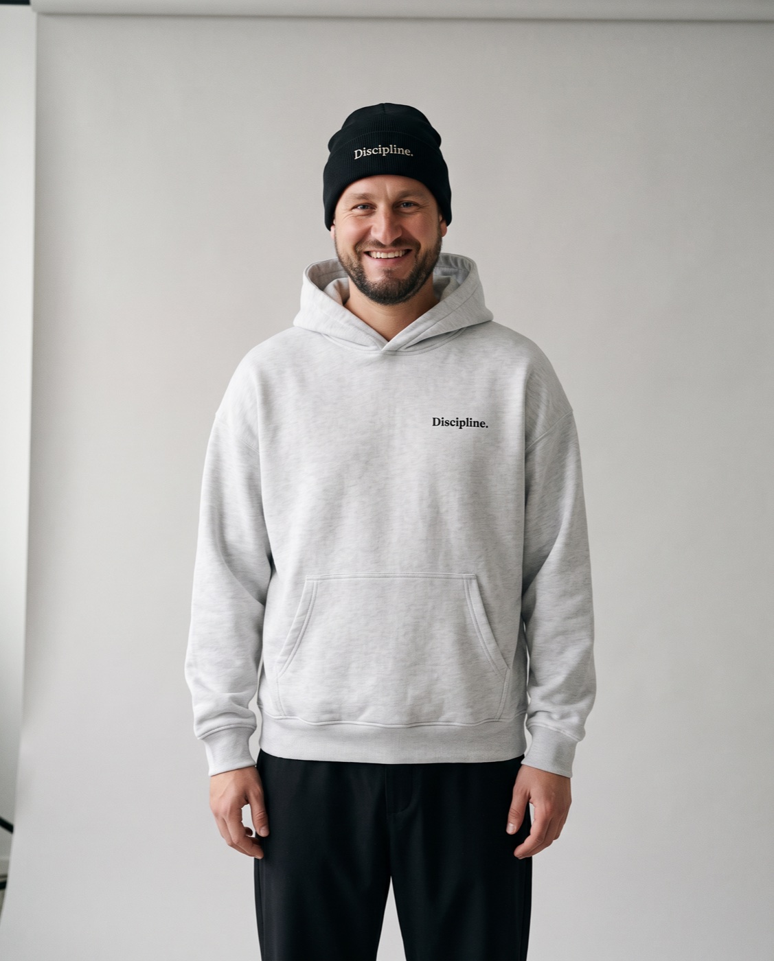 Yves Benini in the studio in the Oversized Hoodie in Heather Grey and the black Rib Beanie